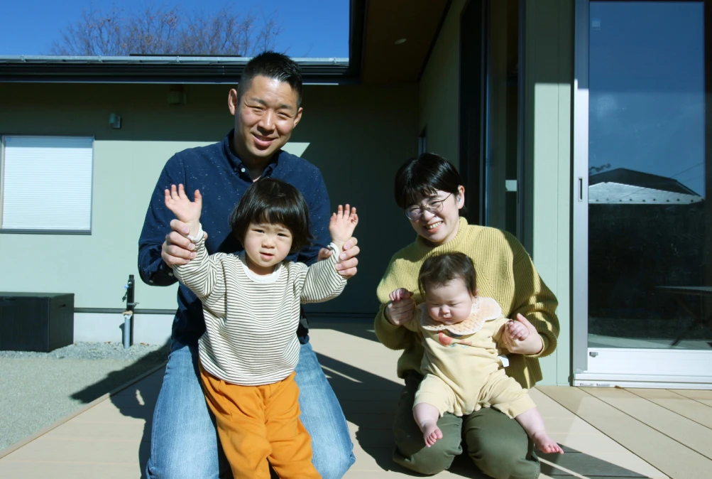 家の外で家族が楽しそうに過ごしている