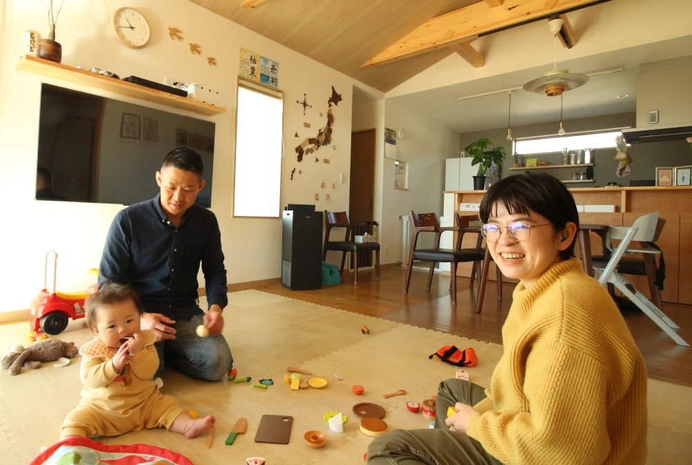 家の中で家族が床で遊んでいる(リビング)