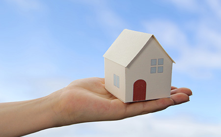 ミニチュアの家を持つ手